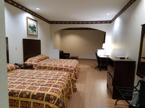 a hotel room with two beds and a desk at Scott Inn & Suites - Downtown Houston in Houston