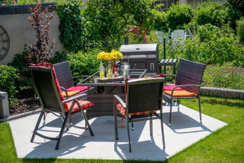 a patio with a table and chairs on the grass at Design-Apartments by Ulrike Horster in Bensheim