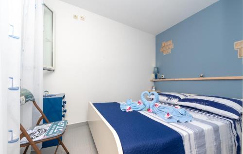 a bedroom with a bed with blue and white sheets at Apartman Sunrise in Vela Luka