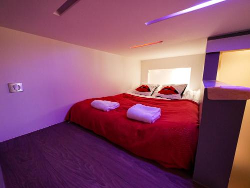 um quarto com uma cama vermelha e 2 almofadas em Gites Spa Strasbourg - L'annexe em Furdenheim