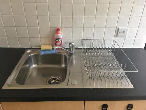 a kitchen sink with a dish drying rack next to it at Superb Peaceful 1 bed apartment in St George. in Bristol