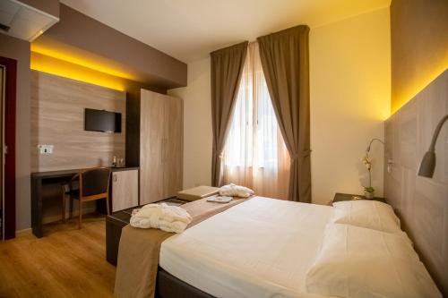 a hotel room with a large bed and a desk at Hotel Lory My Wellness SPA in Chianciano Terme