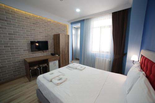 Una habitación de hotel con una cama con toallas. en Taksim Park Suites en Estambul