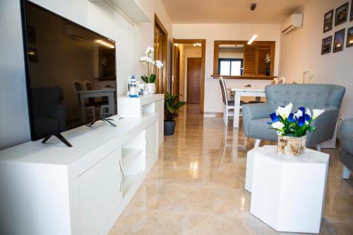 a living room with a flat screen tv on white cabinets at Apartment las sirenas WiFi 100 Mb in Roquetas de Mar