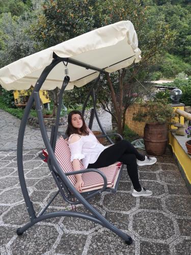 a woman is sitting in a swing chair at Agriturismo Costa di Campo in Vernazza
