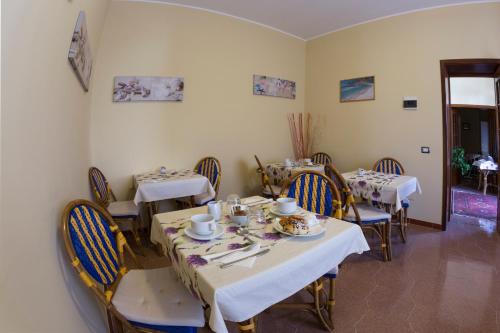 a dining room with tables and chairs with dishes on them at Albergo Moschella in Lampedusa