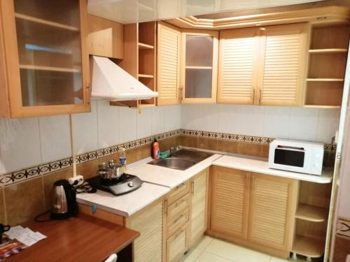 una pequeña cocina con fregadero y microondas en SPACE Aparts and Rooms, en Yekaterinburg