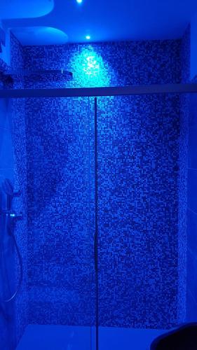 a blue light in a bathroom with a brick wall at Hotel al Sole in Auronzo di Cadore