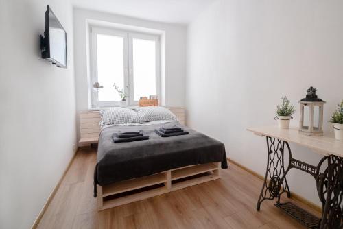 a bedroom with a bed and a desk and a window at THE HEART OF NOWA HUTA - free garage in Krakow