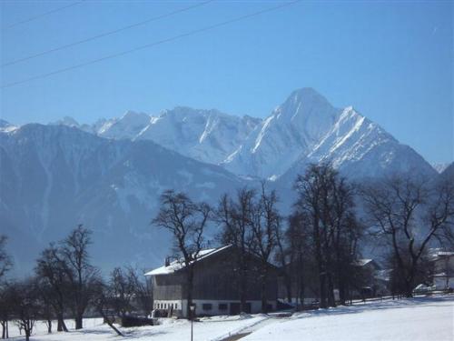 a barn in front of a snow covered mountain at Landhaus Tirol in Zellberg