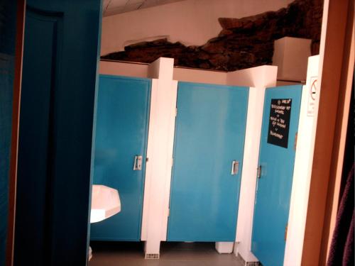 a bathroom with blue stalls and a sink at Giant Canvas Rental Tent Agro-turismo Quinta da Fonte in Figueiró dos Vinhos
