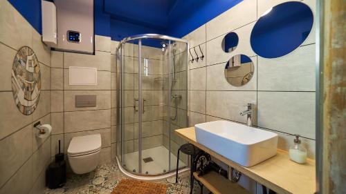 La salle de bains est pourvue d'un lavabo, d'une douche et de toilettes. dans l'établissement Sztukmistrz Magician Art Rooms, à Lublin