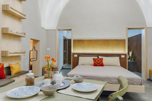 ein Schlafzimmer mit einem Bett und einem Tisch mit Geschirr darauf in der Unterkunft Sacratum B&B Suite Spa in Mesagne