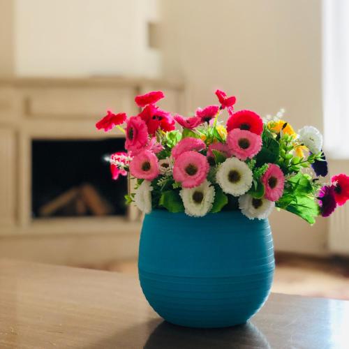 a blue vase filled with flowers on a table at Hotel Tao in Batumi