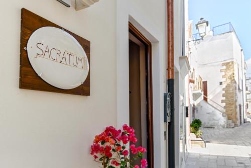 a sign on the side of a building with flowers at Sacratum B&B Suite Spa in Mesagne
