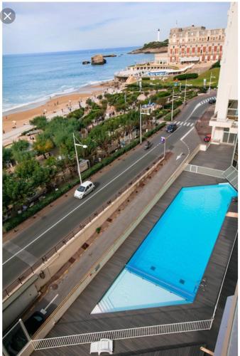 - une vue sur la plage depuis le balcon d'un hôtel avec 2 piscines dans l'établissement Studio Victoria Surf, à Biarritz