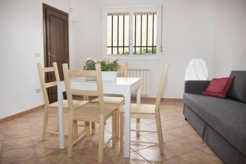 una mesa y sillas en una sala de estar con sofá en Lisetta's house, en Monreale