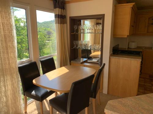 a dining room with a table and chairs and a window at Private Countryside Holiday Cabin 10 mins from Brighton in Brighton & Hove