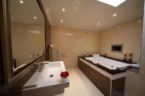 un ampio bagno con vasca e grande vasca da bagno di The Fairview Boutique Hotel a Killarney