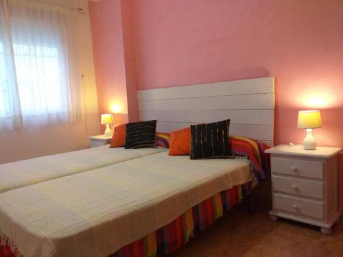 um quarto com uma cama e duas mesas de cabeceira e dois candeeiros em Arrecife de las Sirenas em Almeria
