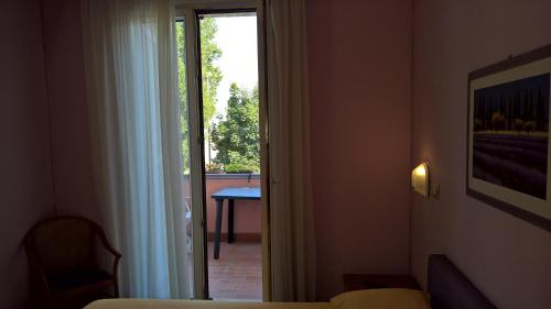 a hotel room with a door open to a balcony at Hotel Ristorante alla Campagna in San Giovanni Lupatoto