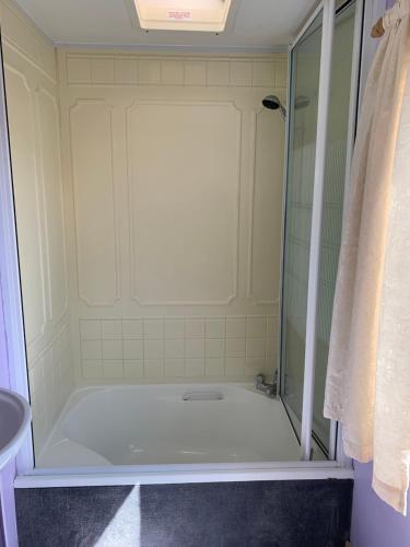 een badkamer met een douche en een bad bij Private Countryside Holiday Cabin 10 mins from Brighton in Brighton & Hove