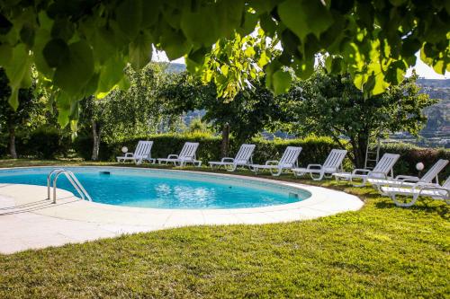 a group of lounge chairs around a swimming pool at Quinta Das Rossadas in Cinfães