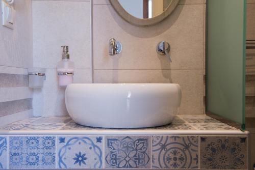 a bathroom with a white sink and a mirror at Kamares House Apartments & Studios in Vourvourou