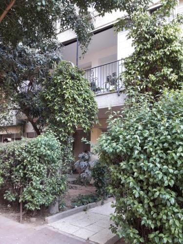 a building with a balcony and trees in front of it at Lovely apartment premium location in Ramat Gan