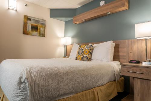 a bedroom with a bed and a desk with a lamp at Days Inn by Wyndham Niagara Falls Centre St By the Falls in Niagara Falls