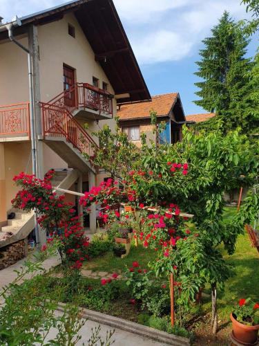 a house with red flowers in front of it at Apartment Kantarije in Sarajevo