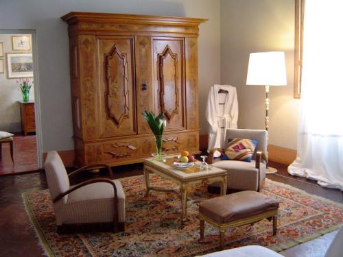 a living room with two chairs and a large wooden cabinet at Le Tre Stanze in Florence