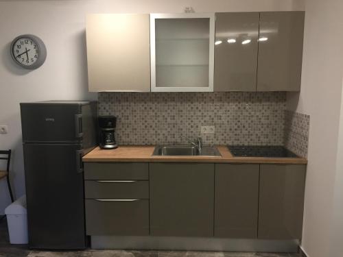 een keuken met een zwarte koelkast en een spoelbak bij Villa Olea in Punat