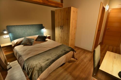 a bedroom with a large bed with a blue headboard at El Pontón de Lanchares in Lanchares