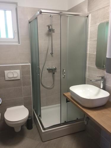 a bathroom with a shower and a toilet and a sink at Villa Olea in Punat