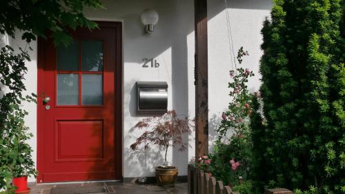 a red door of a house with a mailbox on it at Ruhiges Apartment Nürnberg Süd Ost - Nähe Messe - mit Wallbox in Nuremberg