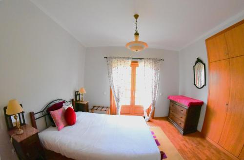 a bedroom with a white bed and a window at Quinta das Ameixas - Country & Nature in Arouca