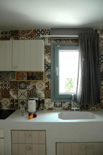 a kitchen with a sink and a window at Kalypso House in Pera Gyalos
