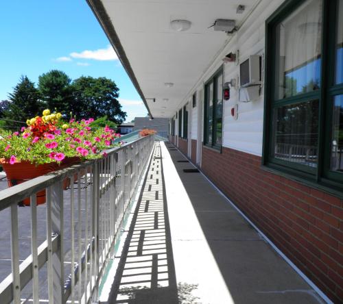 a balcony of a building with flowers on it at Travelers Inn in Brunswick