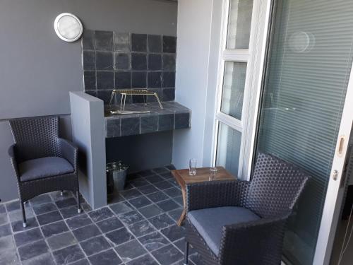 bagno con due sedie, lavandino e tavolo di Field's Rest: The Apartment a Port Elizabeth