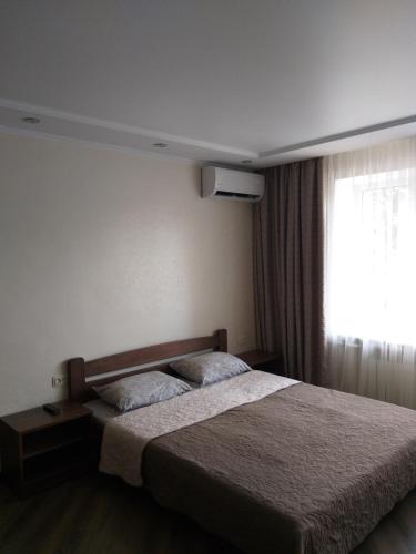 a hotel room with a bed and a window at Затишна квартира в центрі in Vinnytsya