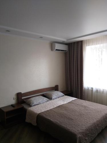 ヴィーンヌィツャにあるЭлитная квартира в центре Винницыのベッドと窓が備わるホテルルーム