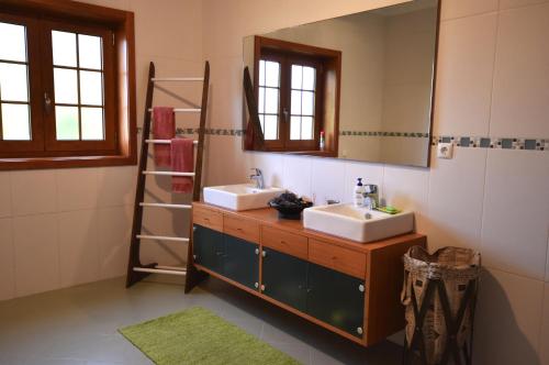 a bathroom with two sinks and a mirror at Quinta das Ameixas - Country & Nature in Arouca