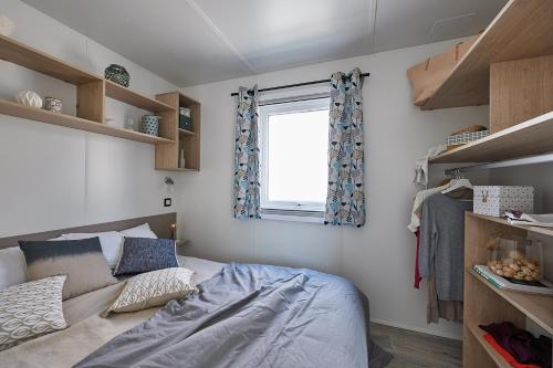 Habitación pequeña con cama y ventana en Le Clos des Genets, en Quend