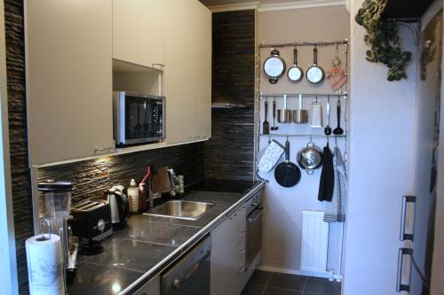 a kitchen with a sink and a counter with utensils at City Apartment Haapaniemenkatu in Kuopio