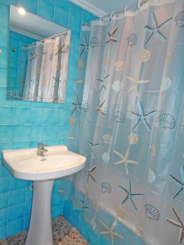 a bathroom with a sink and a shower curtain at ROMA 11 GANDÍA - Alquiler a familias in Gandía