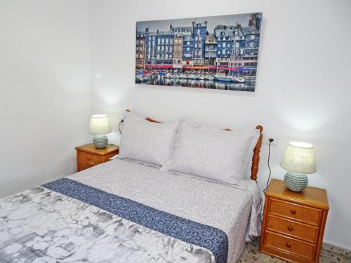 a bedroom with a bed and two night stands with two lamps at ROMA 11 GANDÍA - Alquiler a familias in Gandía