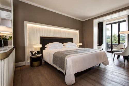 a bedroom with a large bed and a table and chairs at Grand Hotel Castrocaro Longlife Formula in Castrocaro Terme