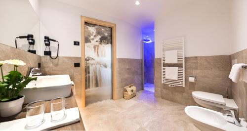 a bathroom with a sink and a toilet and a shower at Wellness Hotel Gran Risa***S in La Villa