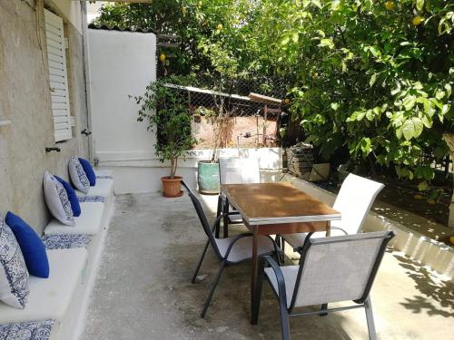 eine Terrasse mit einem Tisch, Stühlen und Bäumen in der Unterkunft Lemontree in Athen